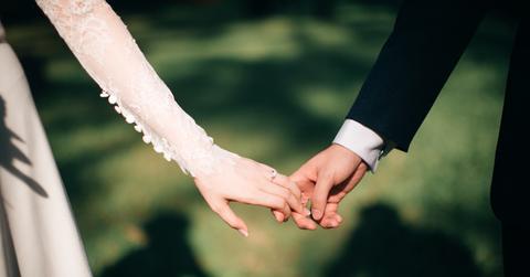A couple holding hands on their wedding day