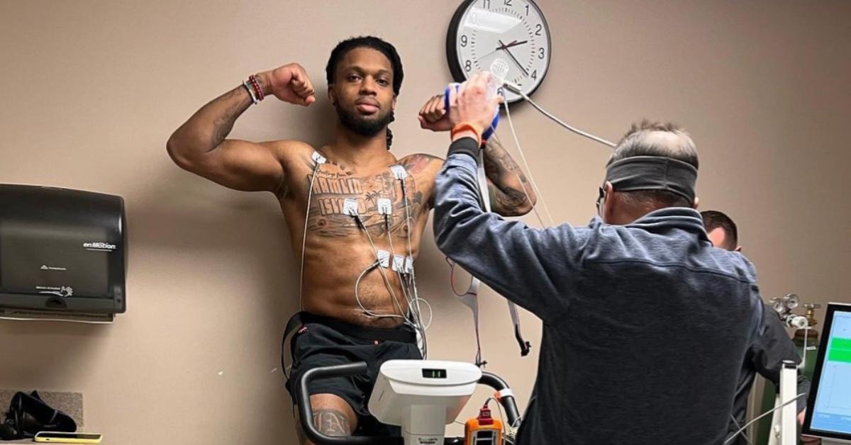 A shirtless Damar Hamlin getting checked out by a physician.