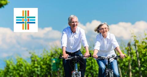 Couple riding bikes and Alignment Healthcare logo