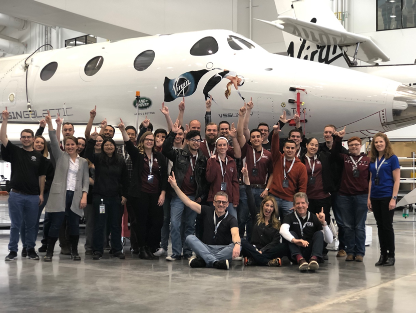 People standing in front of Virgin Galactic spacecraft