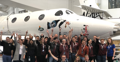People standing in front of Virgin Galactic spacecraft