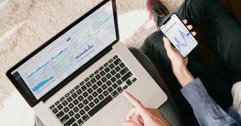 People examining a crypto price chart on the laptop