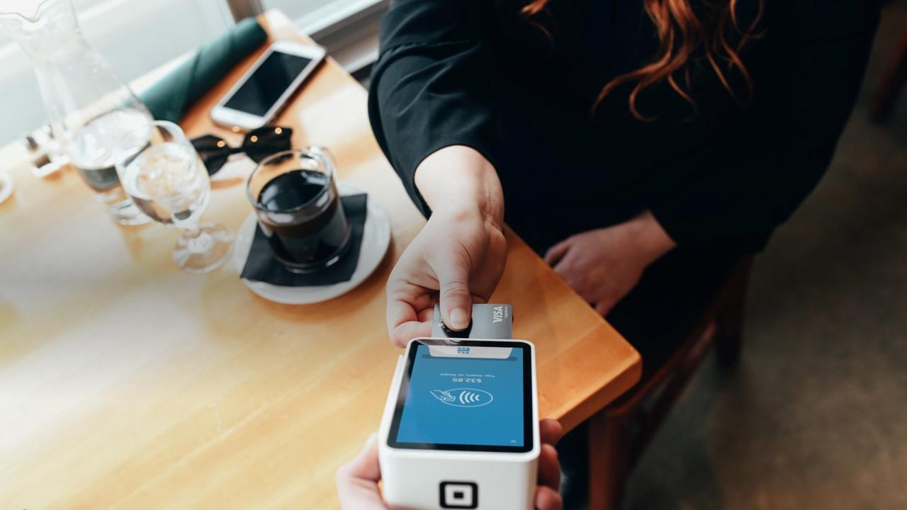 A person using a debit card to make a cash purchase