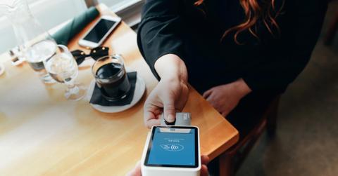 A person using a debit card to make a cash purchase