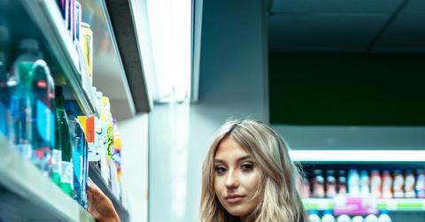 A shopper standing beside a store shelf