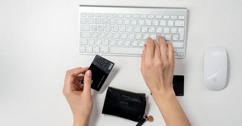 A person entering credit card information on a laptop