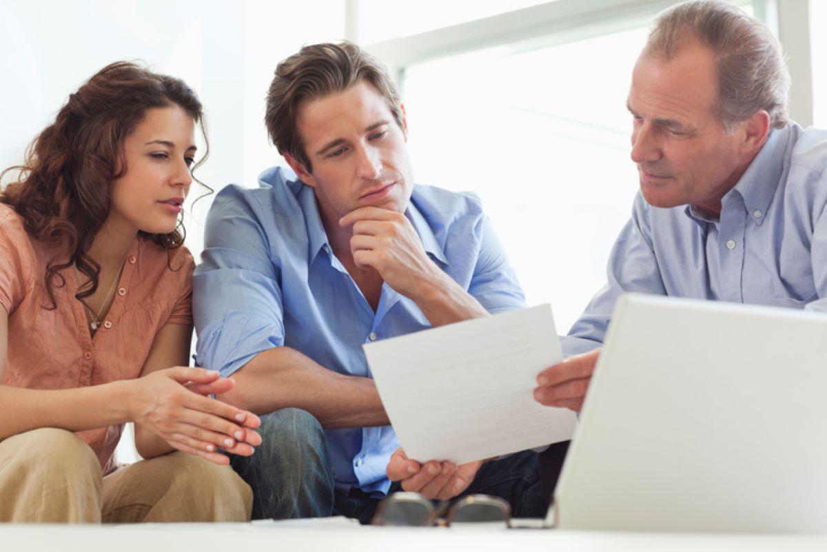 Couple going over paperwork with their financial advisor