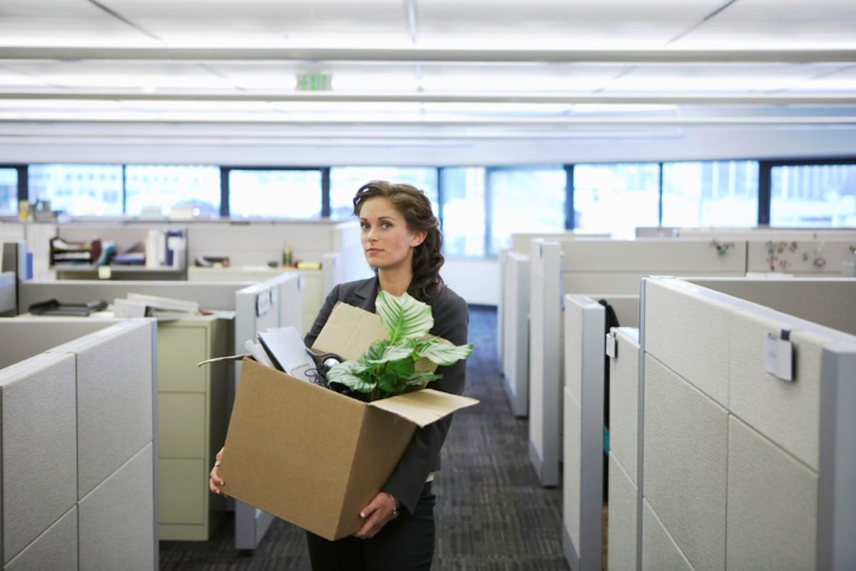 A woman carrying her belongings in a cardboard box