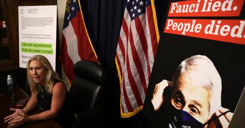 U.S. Rep. Marjorie Taylor Greene with Fauci poster in background