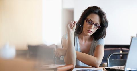 A woman sitting at a desk reviewing her finances.