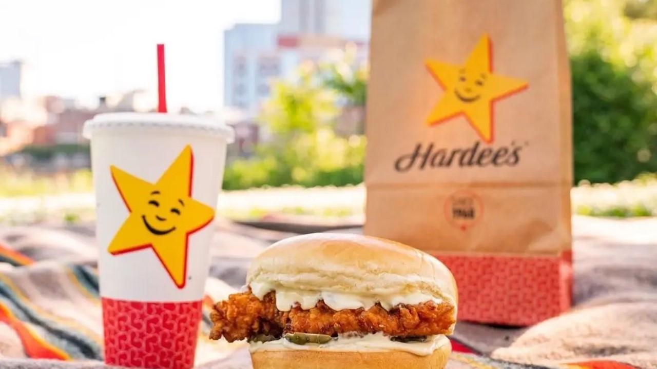 A Hardee's meal sitting on a picnic blanket outside