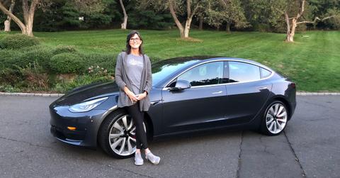 Cathie Wood posing with a Tesla car