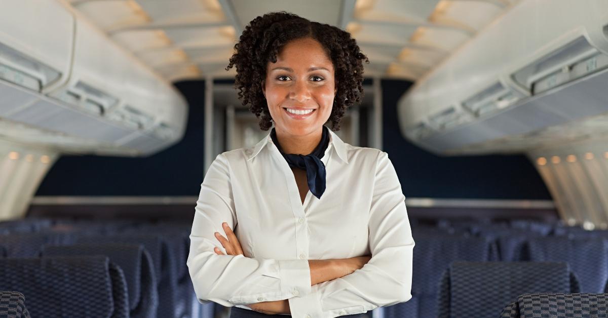 A Flight Attendant Standing In An Airplane. 