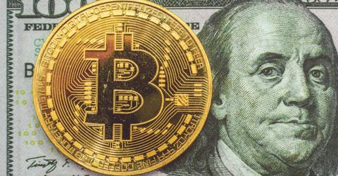 Bitcoin token and a $100 bill