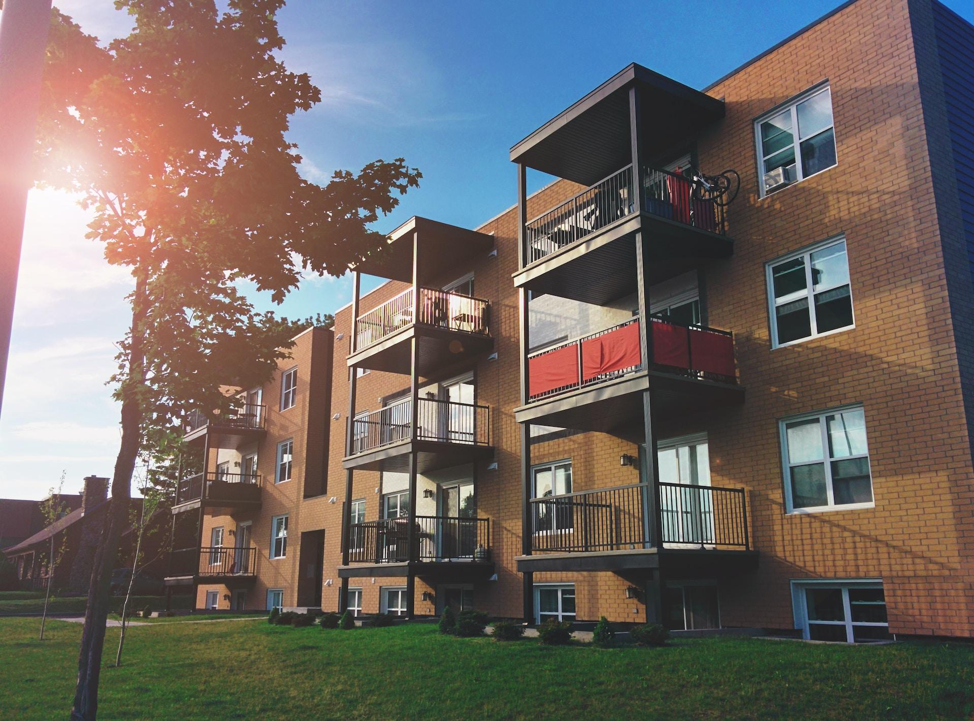 Brown brick four-story building with balcony space