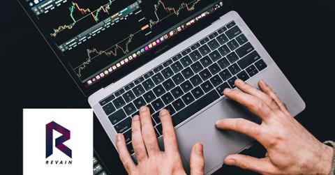 Person using a laptop and Revain logo