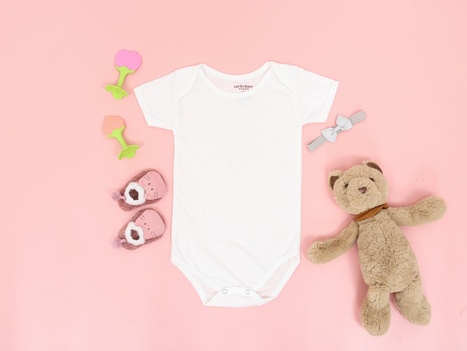 Baby products and goods against a soft pink backdrop