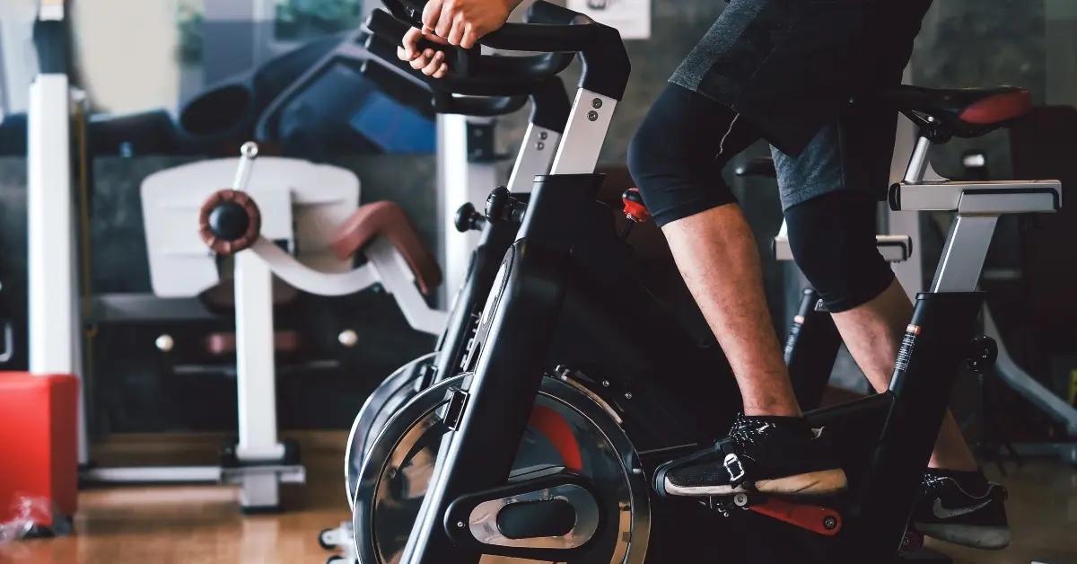 A man using a spin bike at the gym.