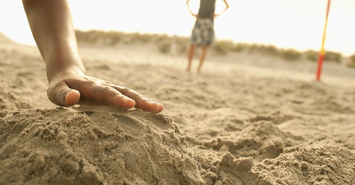 Children playing with sand on the beach