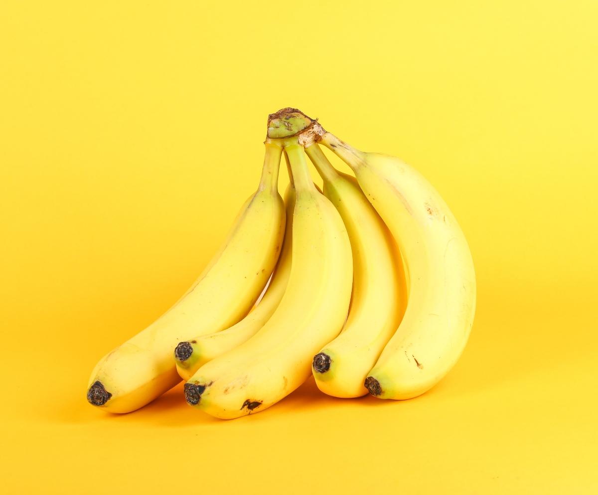 A bunch of bananas with a yellow background