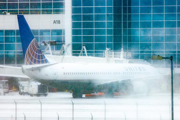 A plane gets de-iced during a winter storm