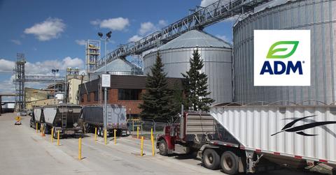 Grain trucks waiting to be loaded and Archer Daniels logo
