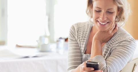 Woman smiling and using cell phone