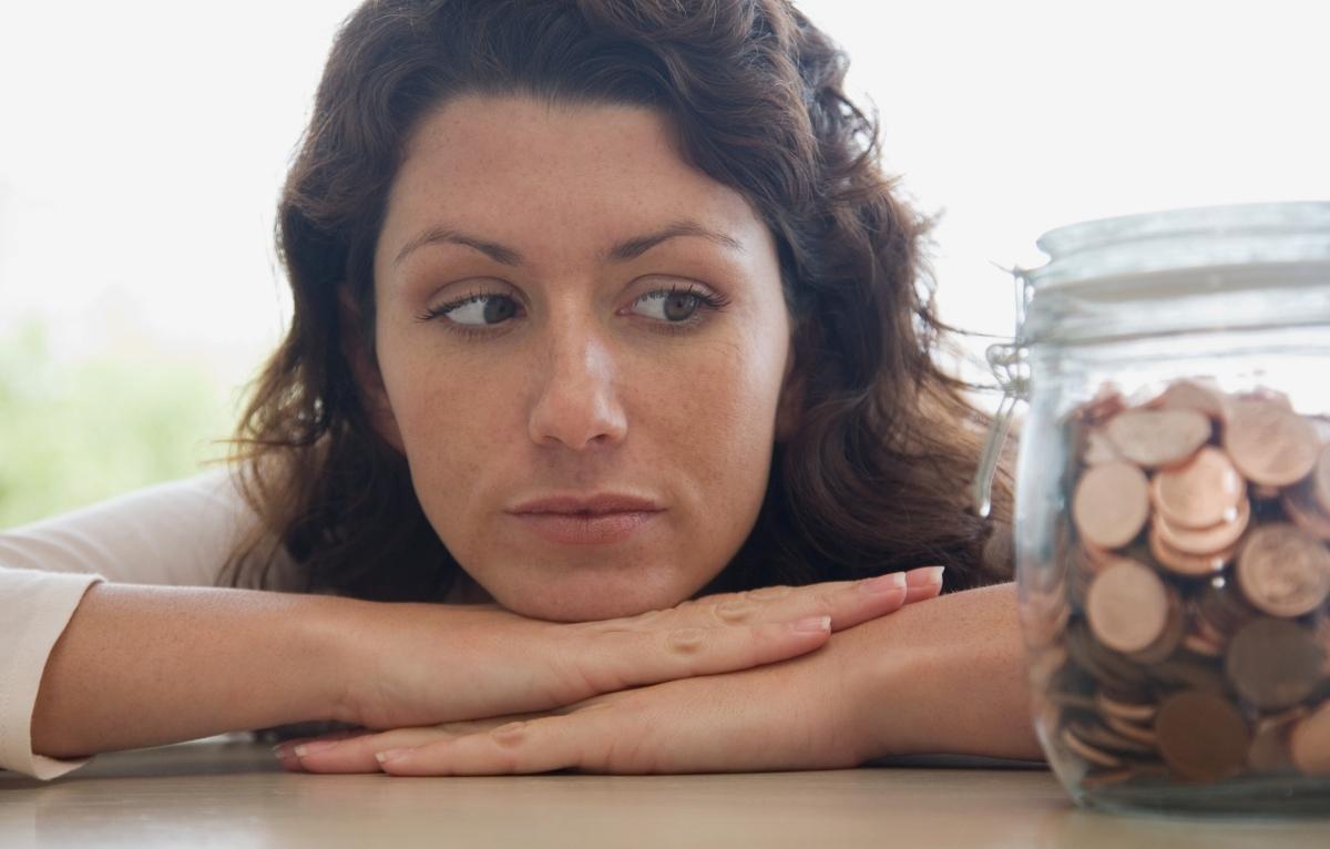 A woman looking at a jar of pennies