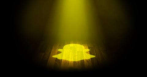 Snapchat logo as yellow spotlight on black background