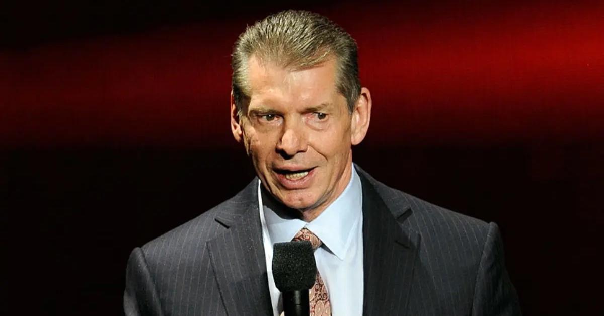 Vince McMahon in suit and tie speaking at a news conference.