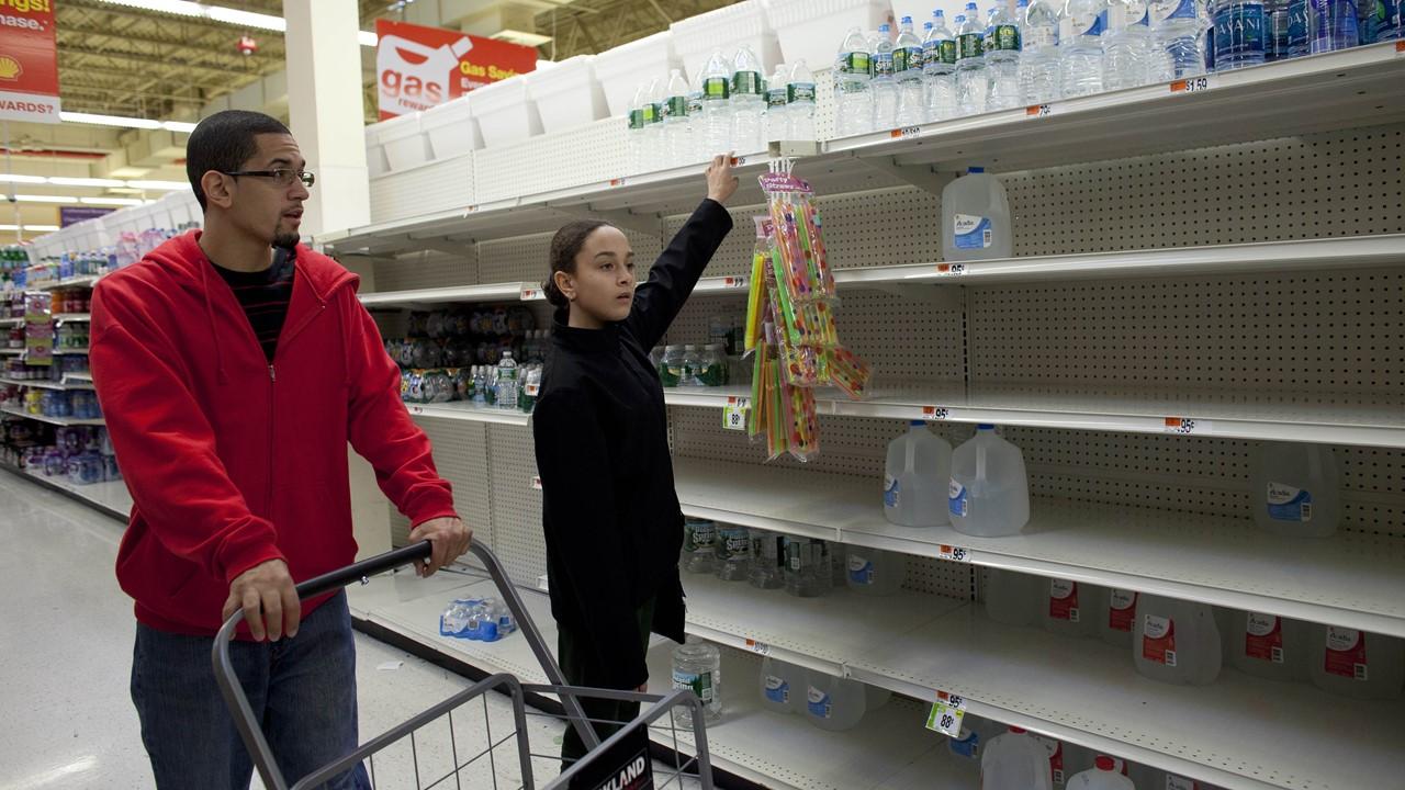 A man and girl looking for distilled water on empty shelves