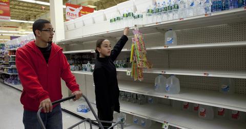 A man and girl looking for distilled water on empty shelves