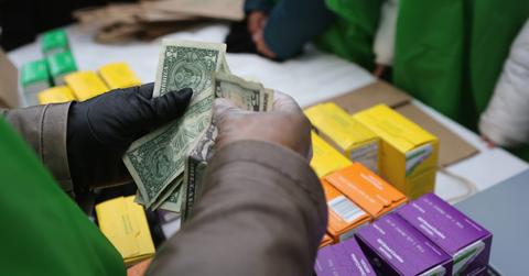 Person counting money for Girl Scout cookie sales