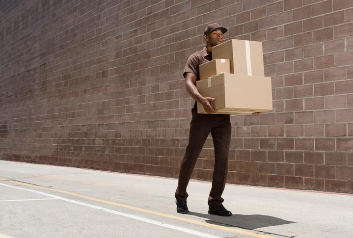 A delivery man dropping off boxes.