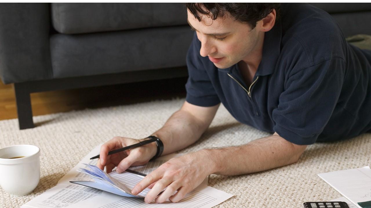 Man writing a check for his student loans