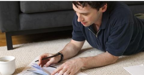 Man writing a check for his student loans