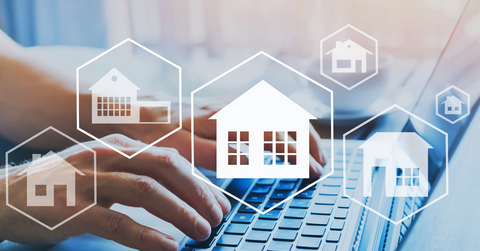 Real estate icons and a person using a laptop