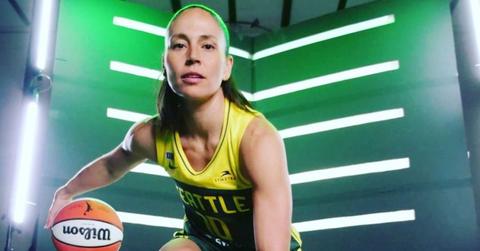 Sue Bird wearing her Seattle Storm uniform and dribbling a basketball