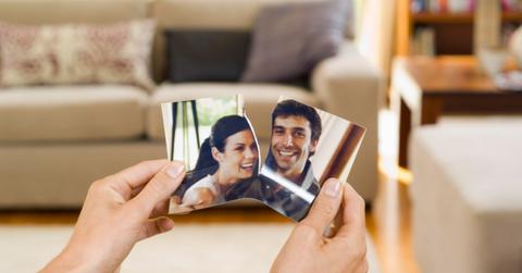 A person tearing a photo in half