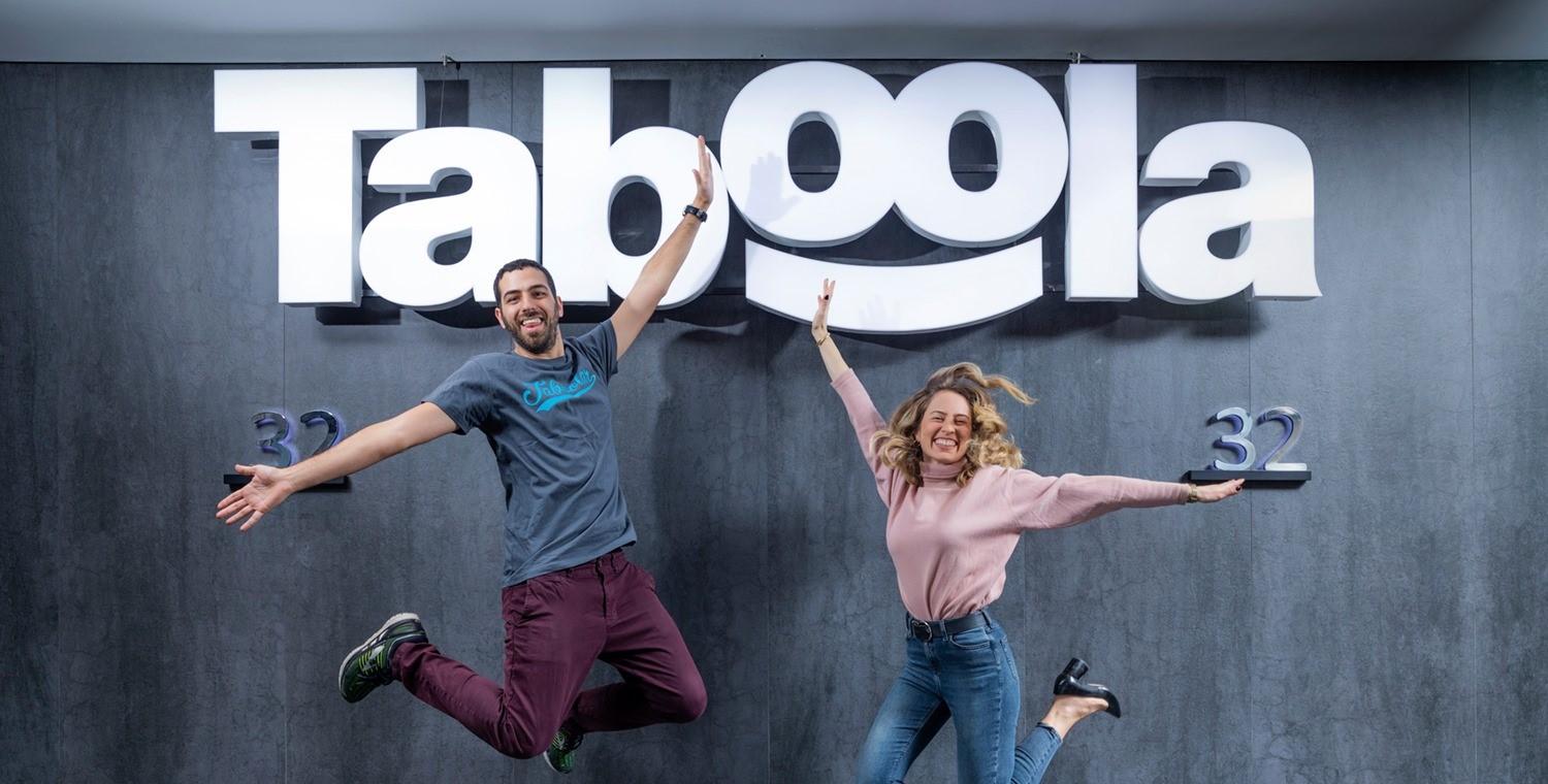 Employees jumping under Taboola sign