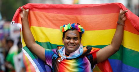 A demonstrator holds up a Pride flag during a Reclaim Pride