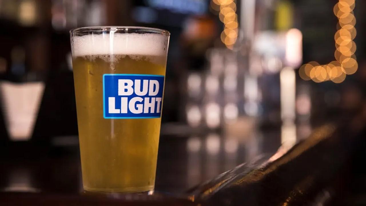 A pint of Bud Light sitting on a bar.