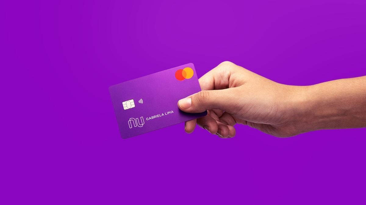 A person holding a Nubank credit card