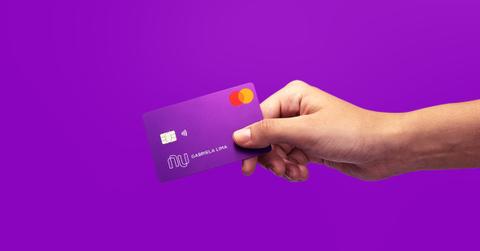 A person holding a Nubank credit card