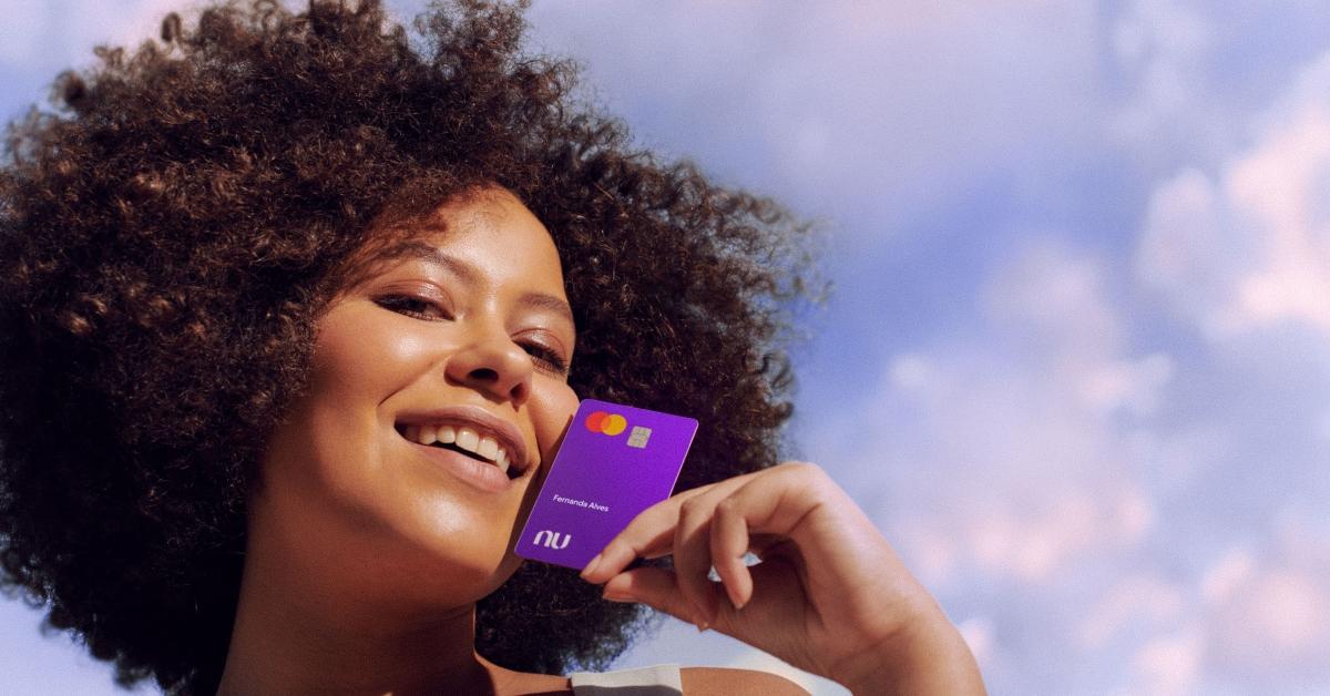 Woman holding a Nubank card