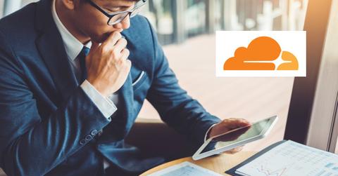 Man looking at data on a tablet and Cloudflare logo