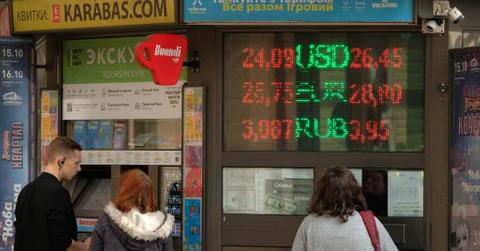 People looking at billboards with the Russian ruble's stock value
