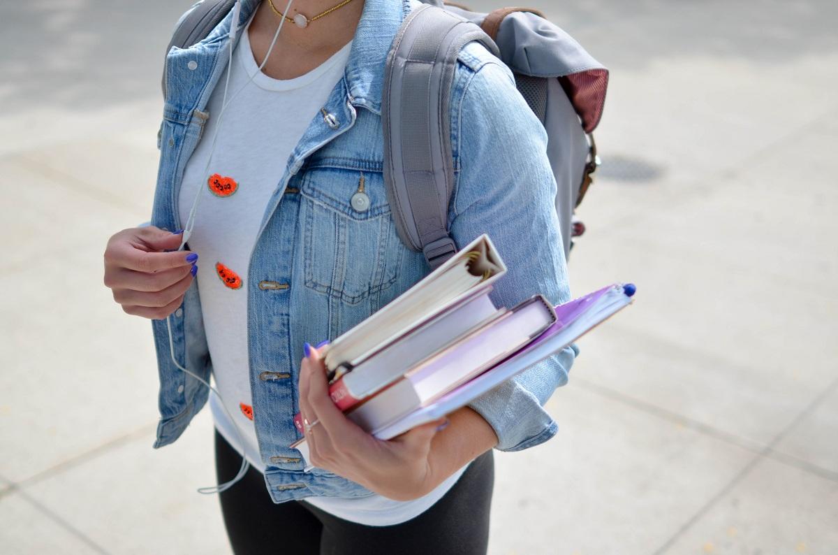 A student carrying books an a backpack