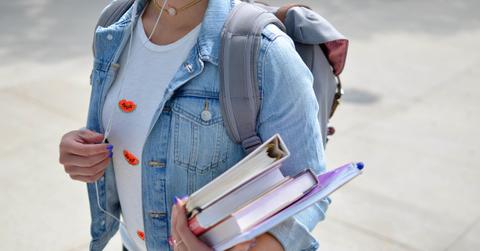 A student carrying books an a backpack