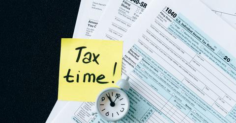 Tax documents and a tax time note with a clock